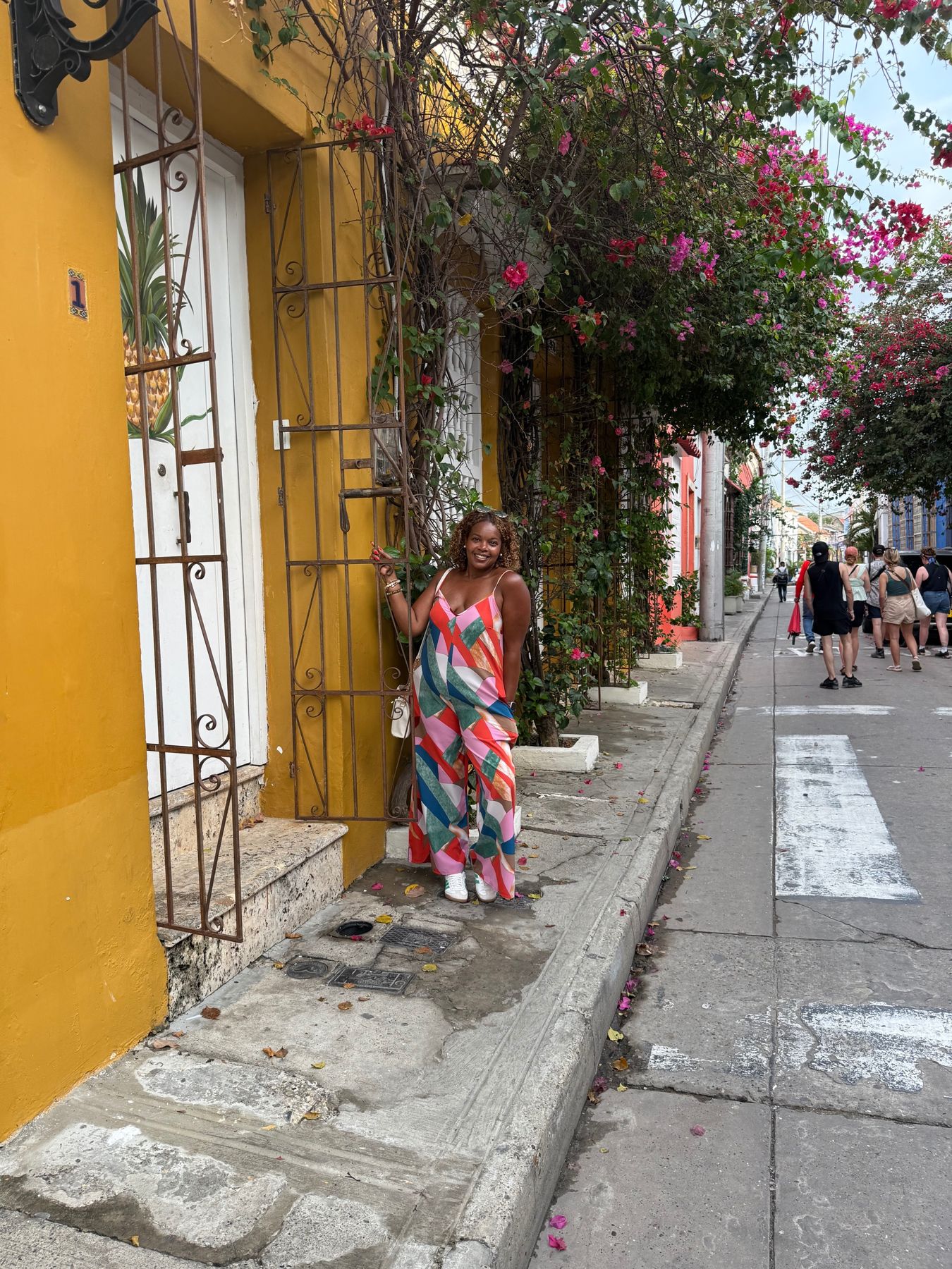 Amy on a colorful street lined with bougainvillea
