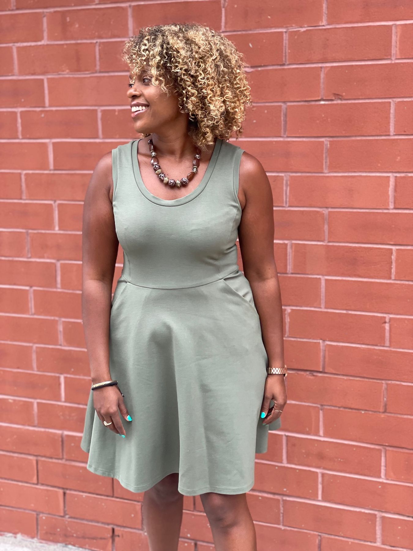 Amy smiling against a brick wall